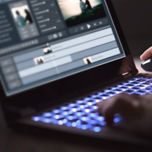 student editing video on laptop